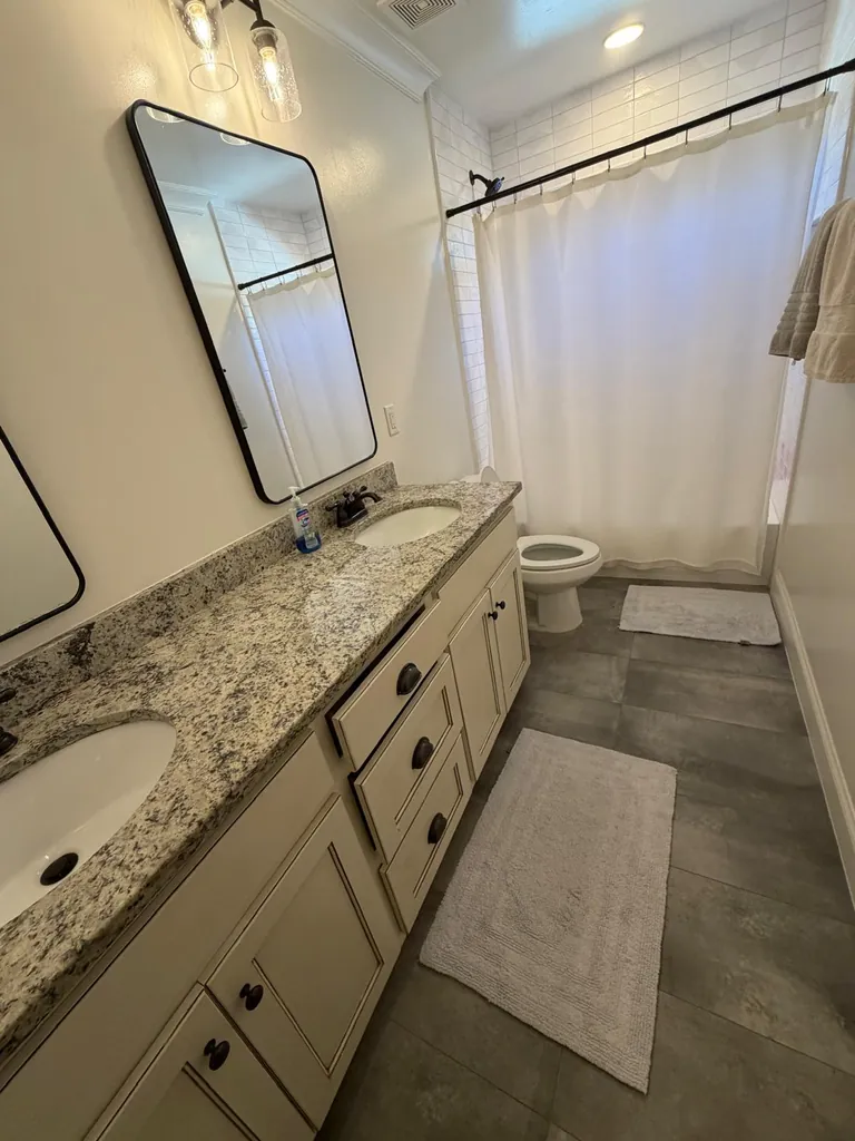 Bathroom with a double vanity and white shower curtain
