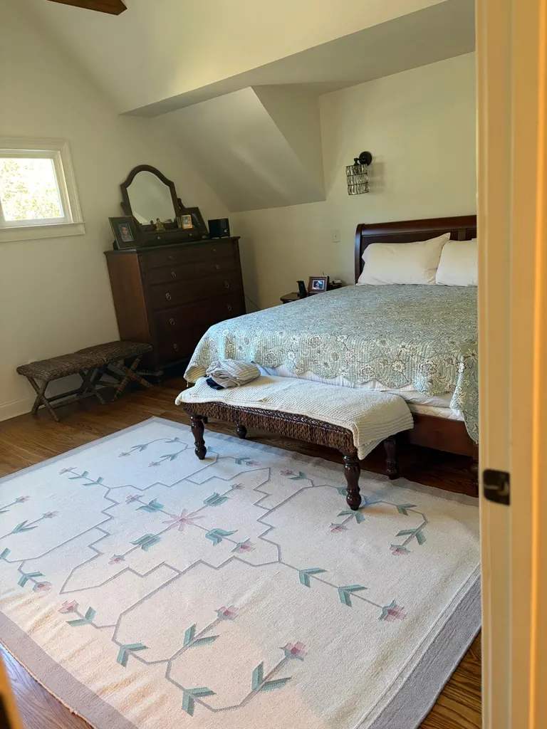 Bedroom with a neatly made bed and patterned rug